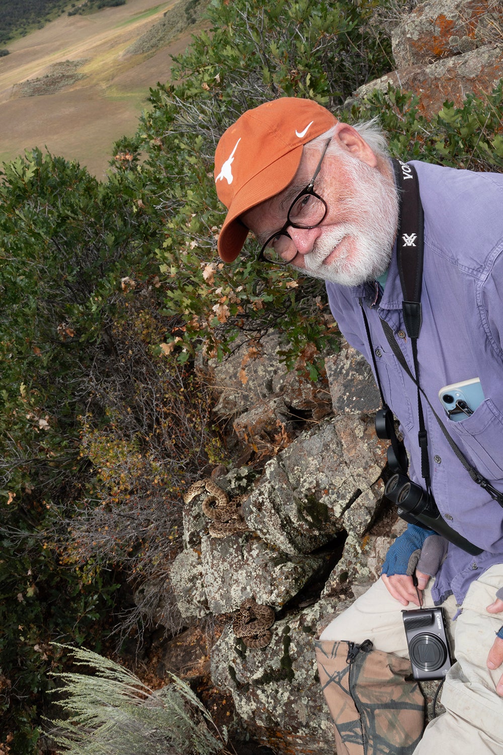 Harry Greene smiling in front of a rattlesnake den